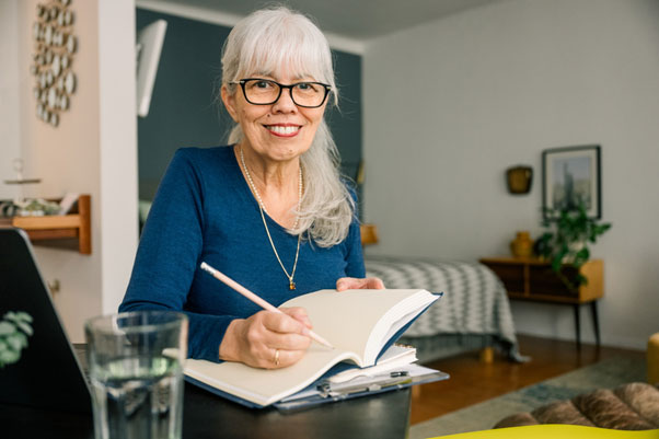 Stuhl mit Aufstehhilfe Seniorin macht Notizen